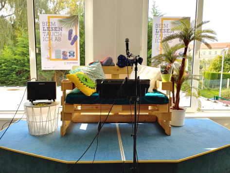 Foto einer kleinen Bühne mit Palleten-Sofa und Mikrofontechnik