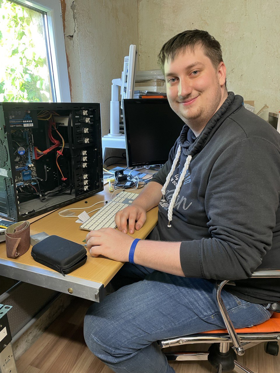 Lukas Ramm sitzt vor einem auseinander gebauten PC
